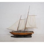 A wooden model of a two masted boat on stand - length 128cm, height 125cm