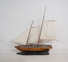 A wooden model of a two masted boat on stand - length 128cm, height 125cm