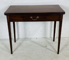 A Georgian mahogany tea table with inlaid decoration on tapering legs.