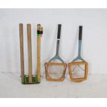 A set of spring loaded cricket stumps on cast iron base, along with a vintage Slazenger tennis