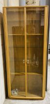 A blonde Ercol double glazed display cabinet - height 213cm, width 93cm and depth 32cm