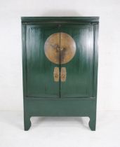 A green painted Japanese cabinet with brass detailing to doors, enclosing two drawers and a secret