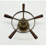 A brass ships wheel with turned wooden handles on brass base - approximately 35cm across