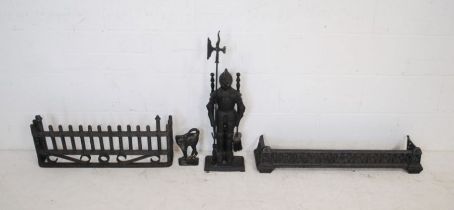 Two metal fire guards along with a set of fire irons and a doorstop in the form of a cat