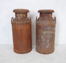 Two weathered metal milk churns, one marked 'WUDL, Melksham'