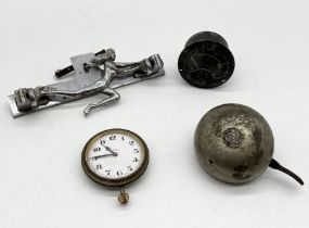 A collection of items including chrome car mascot, Lucas King of the Road bell, Swiss made car clock