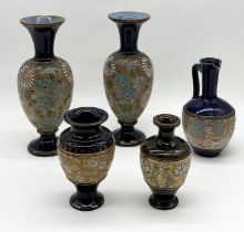 A collection of Royal Doulton stoneware vases and jugs all with gilt decoration including four