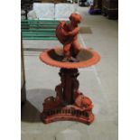 A Victorian weathered red painted cast iron garden water fountain, with stylised dolphin base and