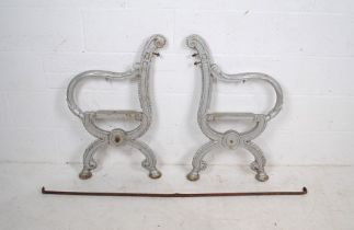 A pair of weathered painted silver cast iron garden bench ends with support bar