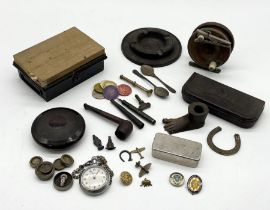 An assortment of various items including miniature brass plane brooches, stopwatch, fishing reel