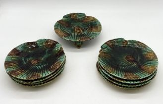 A set of nine majolica scallop shaped plates with mottled brown and green glaze, one on raised