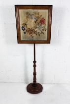 A Victorian pole screen with tapestry decoration.