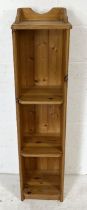 A narrow pine freestanding bookcase with three shelves