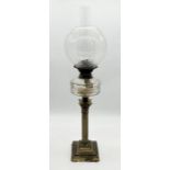 An antique oil lamp on brass column base with etched decoration to shade