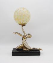 An Art Deco lamp on marble base in the form of a nude lady with mottled spherical glass shade -