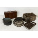A collection of various items including a vintage leather suitcase, garden sieves, cast iron fire