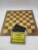 A cased set of draughts along with a board