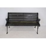 A weathered cast iron garden bench with wooden slatted seat - length 127cm