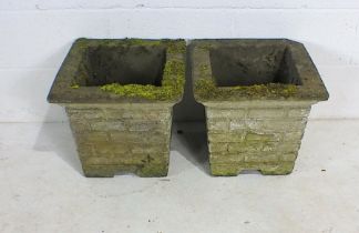 A pair of weathered reconstituted stone garden planters.