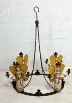A wrought iron hanging candelabra decorated with four Nuremberg style folk art angels