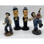 Two pairs of Laurel and Hardy figurines.