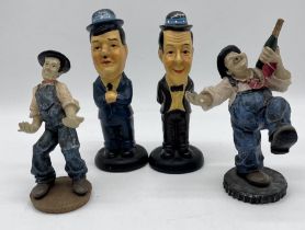 Two pairs of Laurel and Hardy figurines.