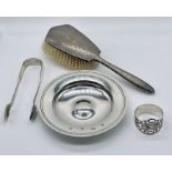 A hallmarked silver dish along with a silver serviette ring, sugar tongs and a dressing table