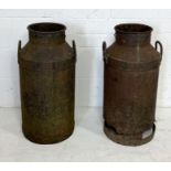 Two weathered milk churns, one with damage to the bottom as shown