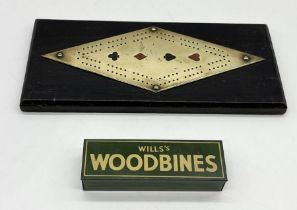 An oak and brass cribbage board decorated with the suits along with a set of Wills Woodbine dominoes