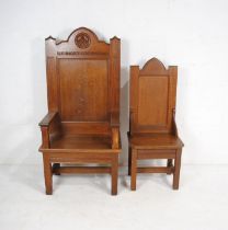 An oak governor's chair with carved detailing, along with an oak assistant governor's chair, both