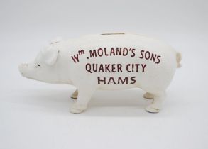 A reproduction cast iron money bank in the form of a pig with advertising to side Wm Molands Sons,