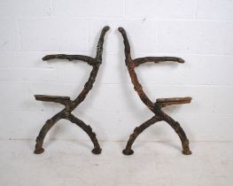 A pair of weathered cast iron twig and branch garden bench ends