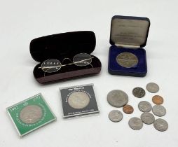 A small collection of coins and a pair of gold plated spectacles along with a QE2 Royal Wedding