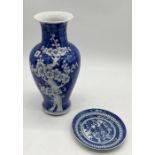 A Chinese blue and white vase with floral decoration along with a saucer