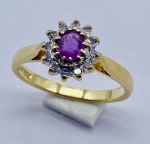 A ruby and diamond cluster ring set in 18ct gold