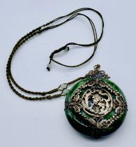 A Japanese green hardstone pendant with SCM decoration of a dragon and pheonix chasing the flaming