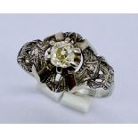 An 18ct white gold Art Deco ring set with a central diamond of approx. 0.25ct and diamond chips to