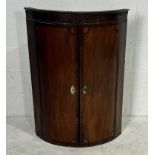 A bow fronted Georgian oak corner cupboard with inlaid detailing.