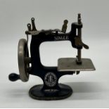 A miniature vintage Singer sewing machine.