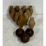 A vintage set of eleven wooden skittles with wooden balls