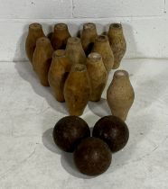 A vintage set of eleven wooden skittles with wooden balls