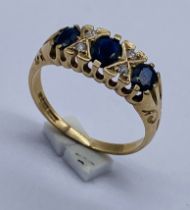 A 9ct gold sapphire three stone ring with diamond infills