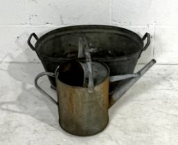 A small galvanised tin bath and watering can.