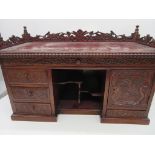 A Japanese break fronted table top jewellery cabinet with carved detailing and various drawers