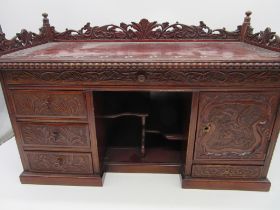 A Japanese break fronted table top jewellery cabinet with carved detailing and various drawers