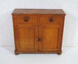 An antique pine narrow dresser base with two drawers stamped 'W' and 'K' and cupboard under - length