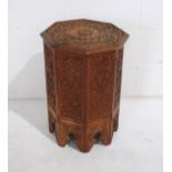 A carved wooden octagonal occasional table with folding base - diameter 43cm, height 58cm