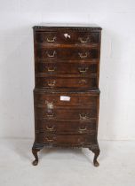 A turn of the century bow-fronted walnut chest of eight drawers, raised on carved cabriole legs -