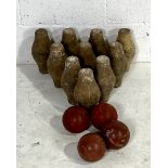 A vintage set of ten wooden skittles along with four rubber skittle balls