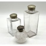 A silver topped scent bottle plus two silver plated topped scent bottles.